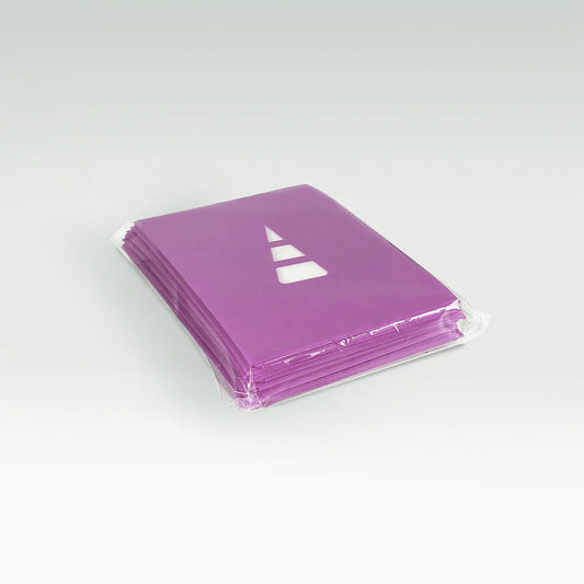 A stack of Unstable Games: Purple Card Sleeves sits ready for use at your gaming table, packaged and sealed with a triangle logo on the topmost bag. Set against a plain background, these bags are ideal for holding card sleeves or other Unstable Games accessories.