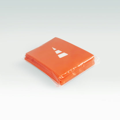 A stack of Unstable Games: Orange Card Sleeves with a white Unstable Games logo, wrapped in clear plastic, on a light gray background.