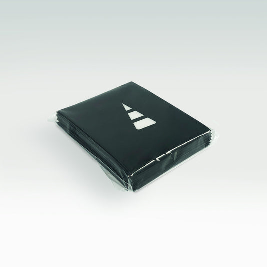 A stack of black card sleeves wrapped in clear plastic, featuring a white geometric logo on the top cover, placed on a light gray background and designed by Unstable Games.