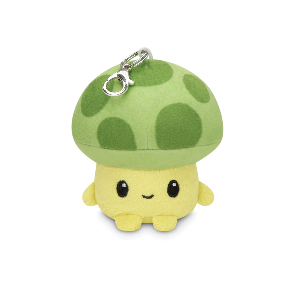 The Sprout Plushie Charm Keychain by Unstable Games features a small, yellow mushroom character with a green cap adorned with darker green spots and comes with a metal clip attached to the top.