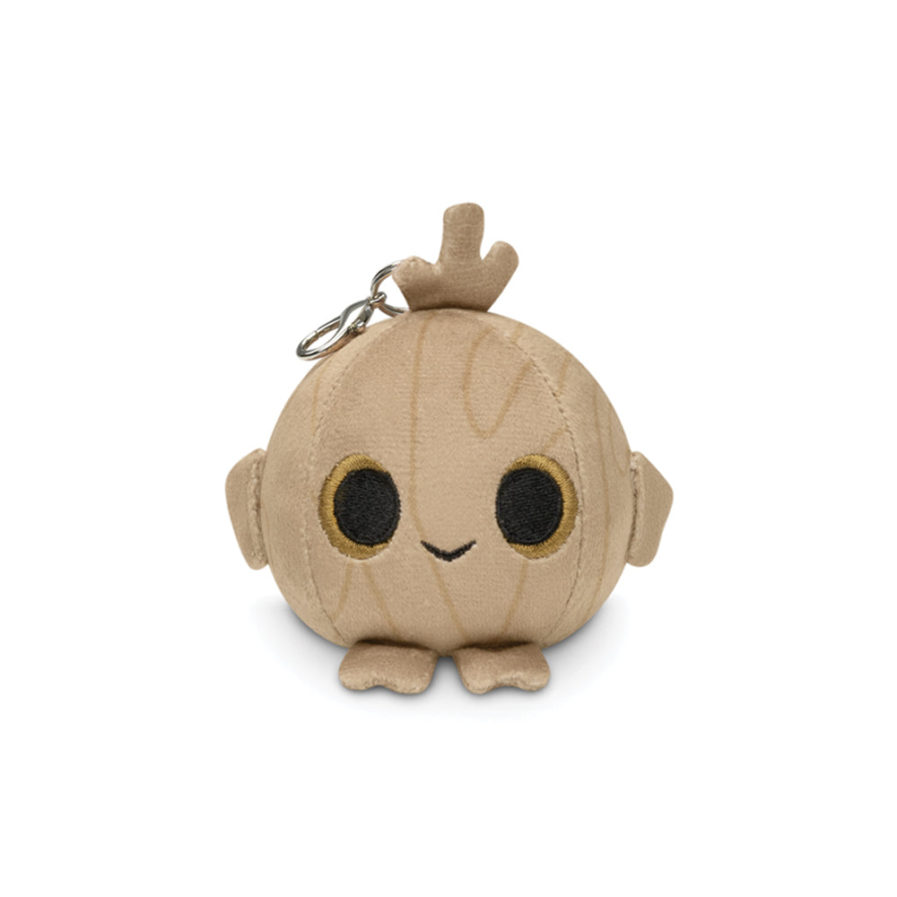 The Timber Plushie Charm Keychain by Unstable Games is a round, plush toy that resembles a tree stump with a smiley face, black eyes, small arms and feet, and includes an attached keychain loop at the top.