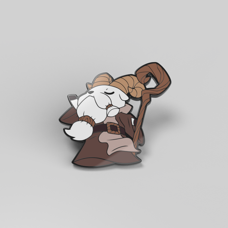 A cartoon character with ram horns and a beard, wearing a robe, and holding a staff. The background is plain gray. Introducing the Cedar the Twig Sage Enamel Pin from Unstable Games.