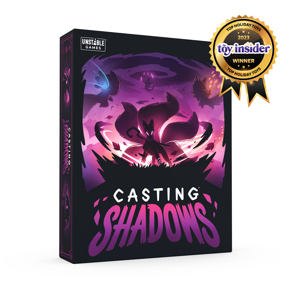 A board game box labeled "Casting Shadows: Base Game" by Unstable Games with a purple and black design featuring mystical creatures, marked as a 2023 toy insider winner.