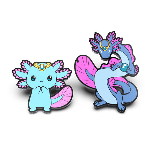 Two Frill Lilypad & Frill the Regenerator enamel pin set, one depicting a cute blue creature with pink wings and a gold crown, casting shadows, and the other a blue dragon with pink wings and a gold monocle. (Brand Name: Unstable Games)