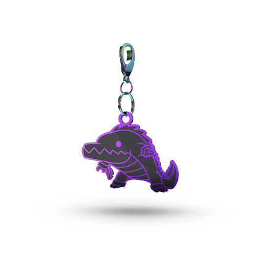 A purple Swamp Monster enamel keychain with a metal clip, depicted in a minimalistic style on a white background by Unstable Games.
