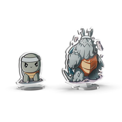 The Casting Shadows: Molten Rock Expansion Standee Set by Unstable Games features two acrylic standees of cartoonish turtle-like creatures. The smaller one showcases a simple design with a neutral expression, while the larger one is more detailed and appears armored.