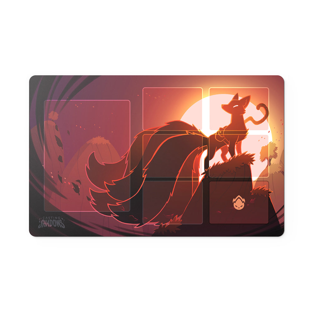 A stylized Casting Shadows: Play Mat Set featuring a silhouette of a fox with a flowing tail standing on a cliff at sunset, in shades of red and orange, by Unstable Games.