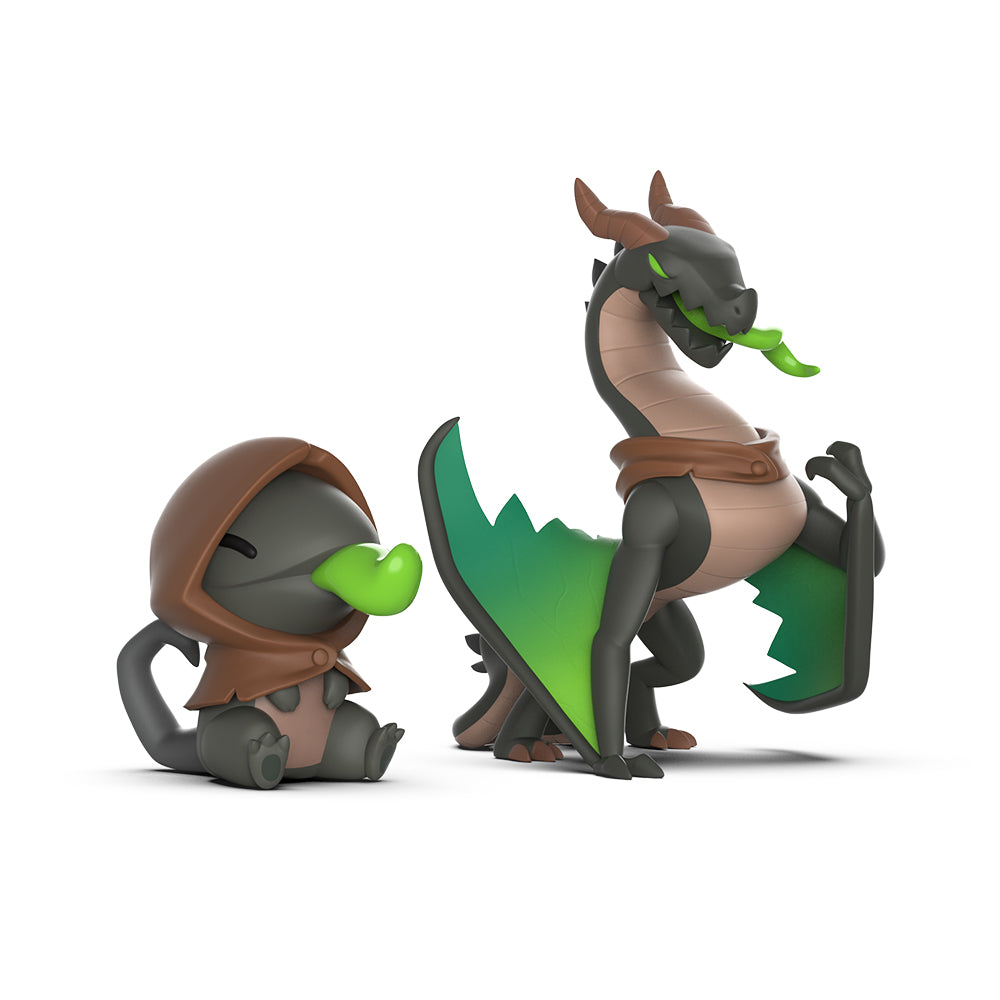 Two "Casting Shadows: Haze Greentongue & Haze the Devastator Vinyl Figure Set" in a cartoon style, one dragon sitting in a cloak and the other standing with wings partially unfurled, isolated on a white background.