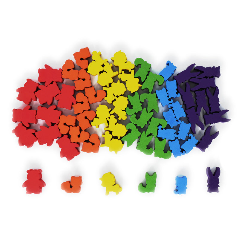 A collection of colorful animal-shaped erasers arranged in a gradient from red to purple. Five erasers, one of each color, are lined up in a row at the bottom, adding a playful touch to your board game accessories and Here to Slay: 6-Class Meeple Set adventures by Unstable Games.