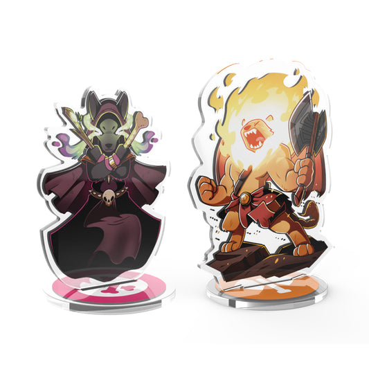 Two stylized acrylic standees: a dark-cloaked figure with green skin and a fiery character wielding a sword, both on clear stands from the Here to Slay: Berserker & Necromancer Expansion Standee Set by Unstable Games.
