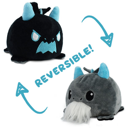 Reversible plush toy showing a transformation from an angry black creature to a smiling gray creature with a white beard, perfect for fans of Unstable Games: Tic Tac K.O. Dragons vs. Unicorns: Lil Grampa Reversible Plushie by Unstable Games.