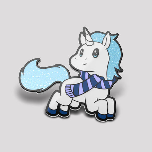 Illustration of a cute cartoon unicorn with a blue and white striped scarf and a flowing blue mane, set in a Winter Wondercorn Pin wonderland, on a light grey background by Unstable Games.
