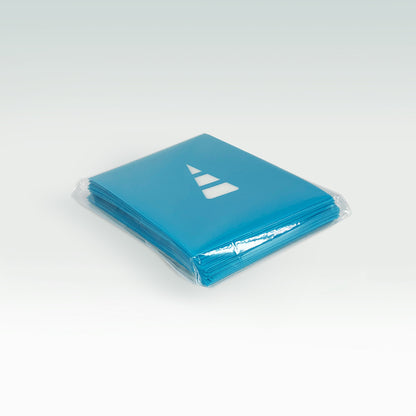 A stack of Unstable Games: Blue Card Sleeves with a white arrow logo, wrapped in transparent card sleeves, on a light gray background.