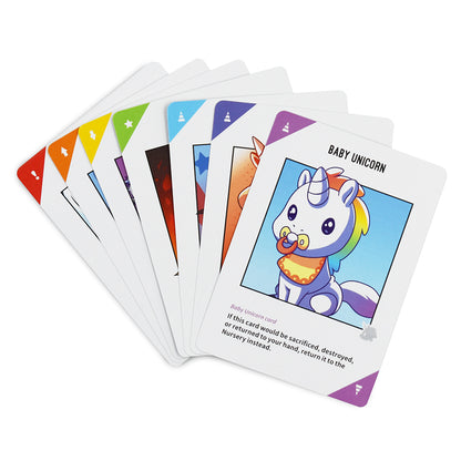 A fan of playing strategic card games displays the "baby unicorn" card from Unstable Unicorns: Base Game by Unstable Games with cartoon illustration and text, among other cards with colored triangle corners.